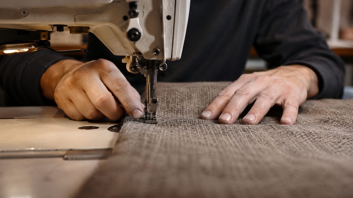 Vakman aan de industriële naaimachine bij Yucel Stoffeerderij
